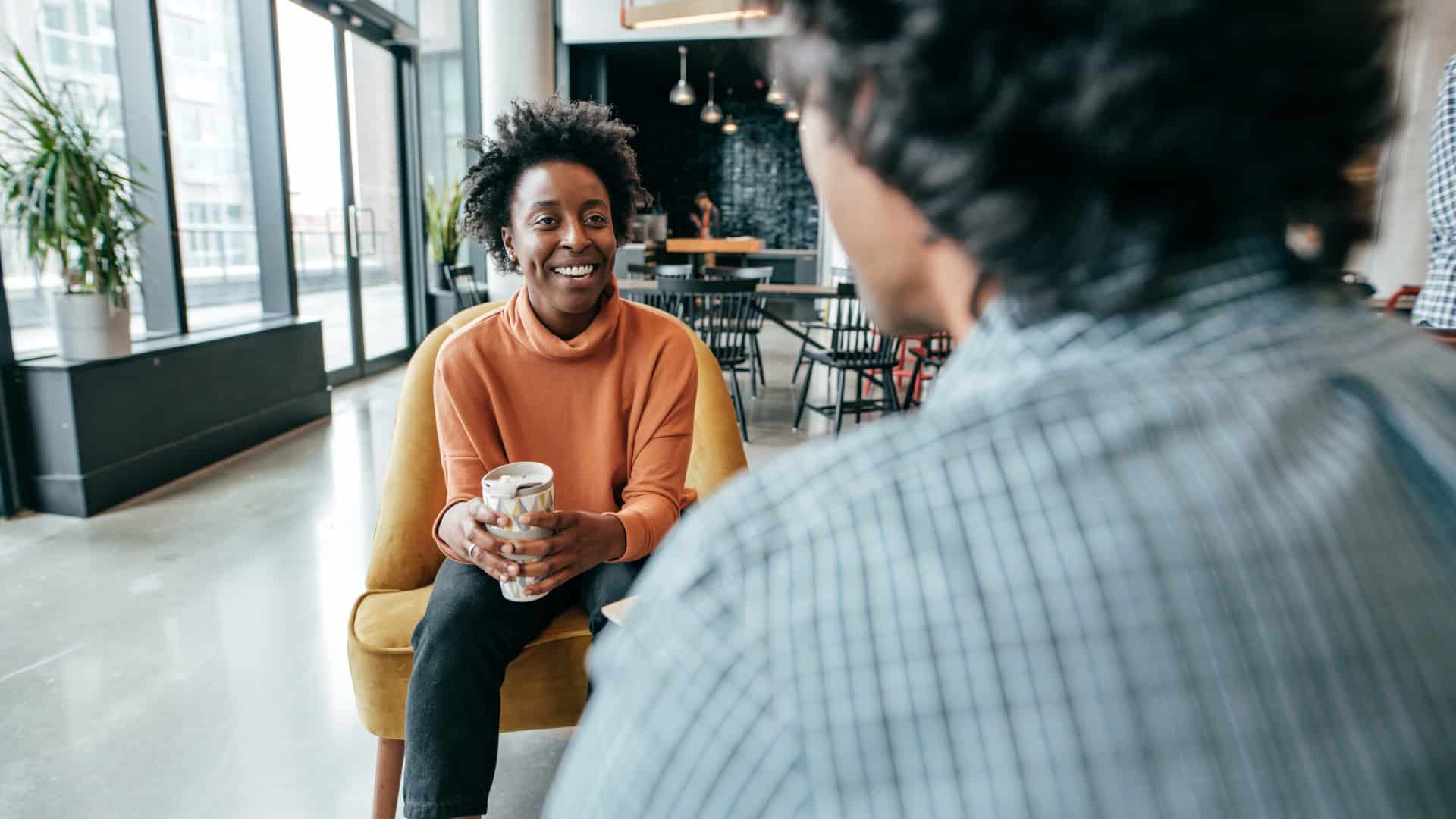 Smiling student in a mentoring conversation on campus